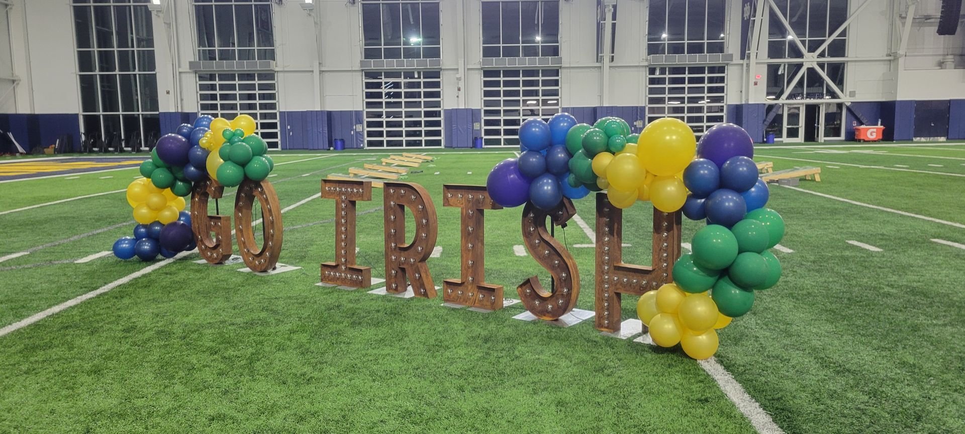 A football field decorated with balloons and wooden letters that say `` go irish ''.