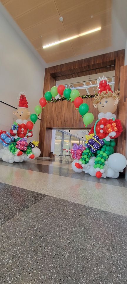 A hallway filled with balloons and decorations for christmas. Giant elfs