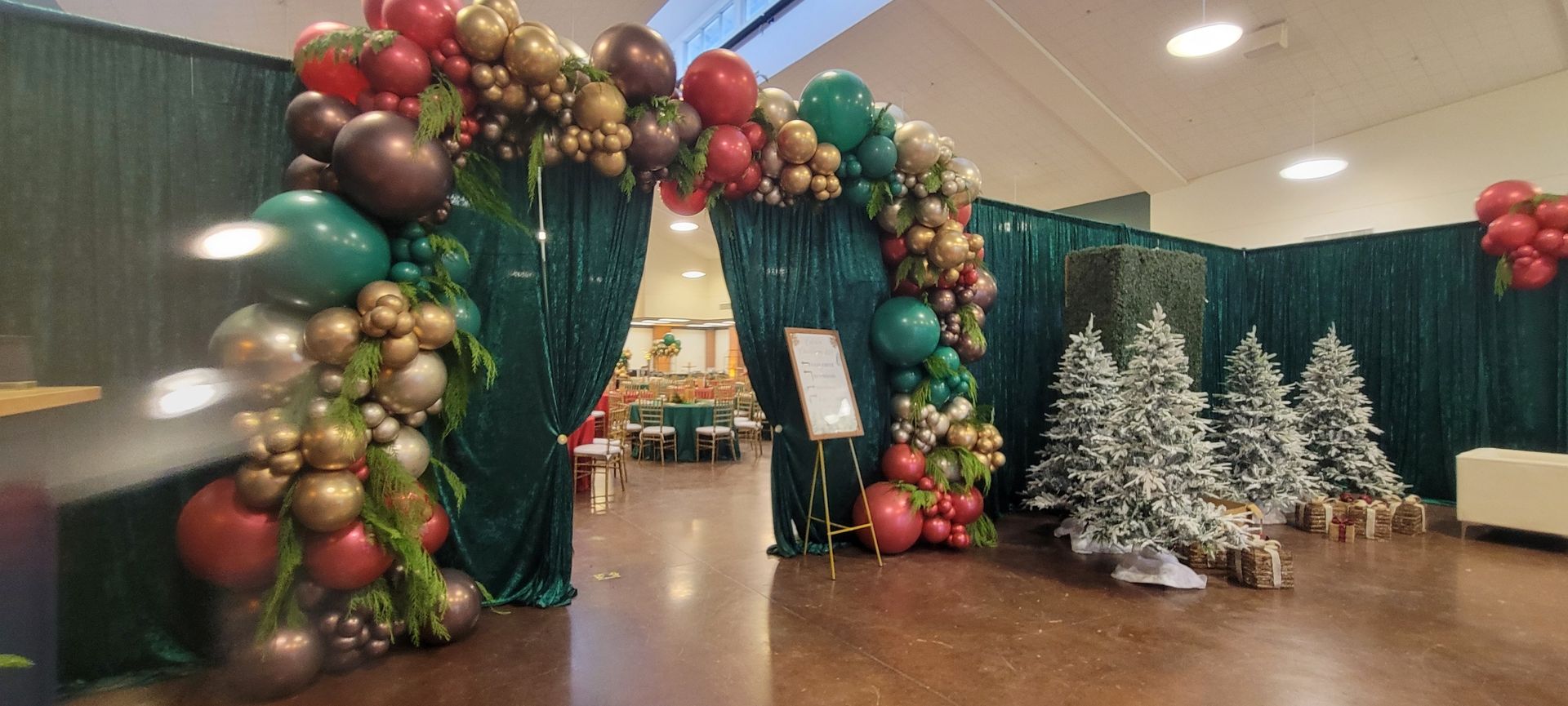 A room decorated for christmas with balloons and trees.