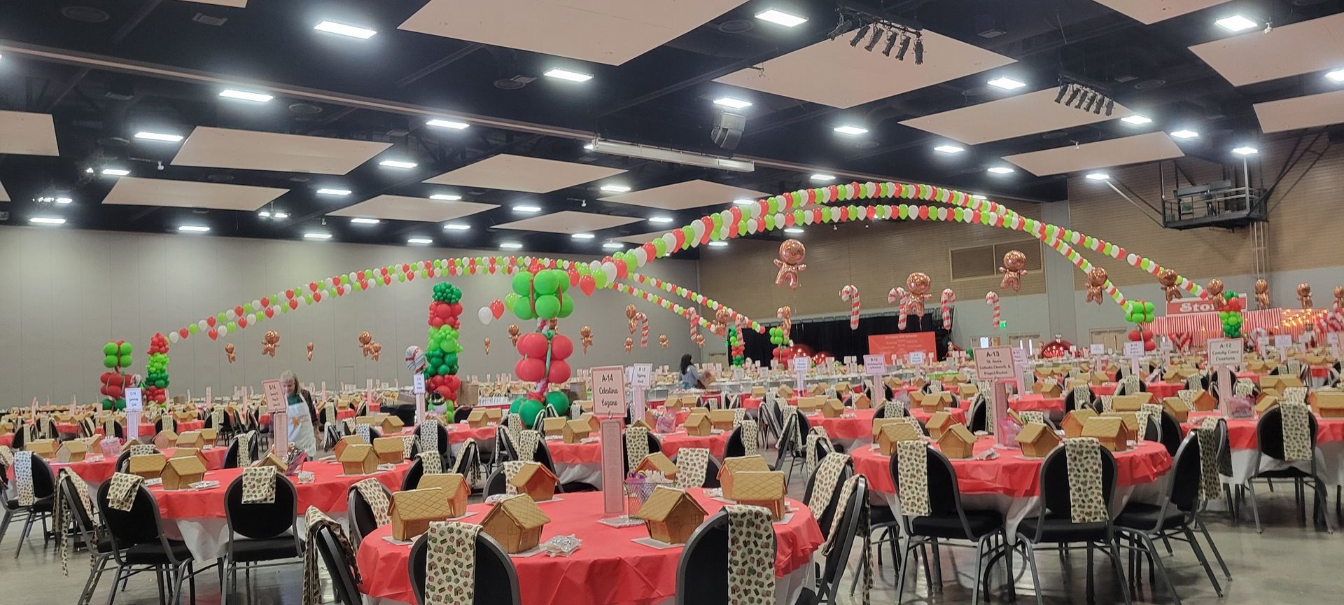 A large room filled with tables and chairs and balloons.