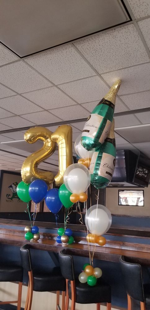 A room decorated with balloons and a bottle of champagne.