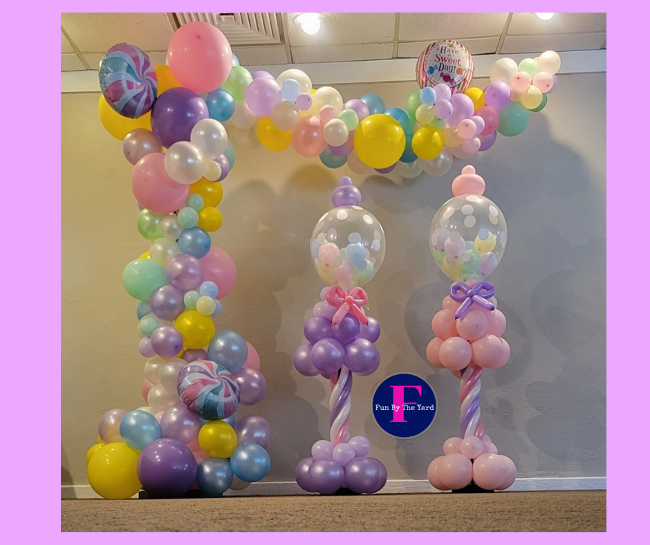 A bunch of balloons are lined up in a room. Bubble gum machines made of balloons