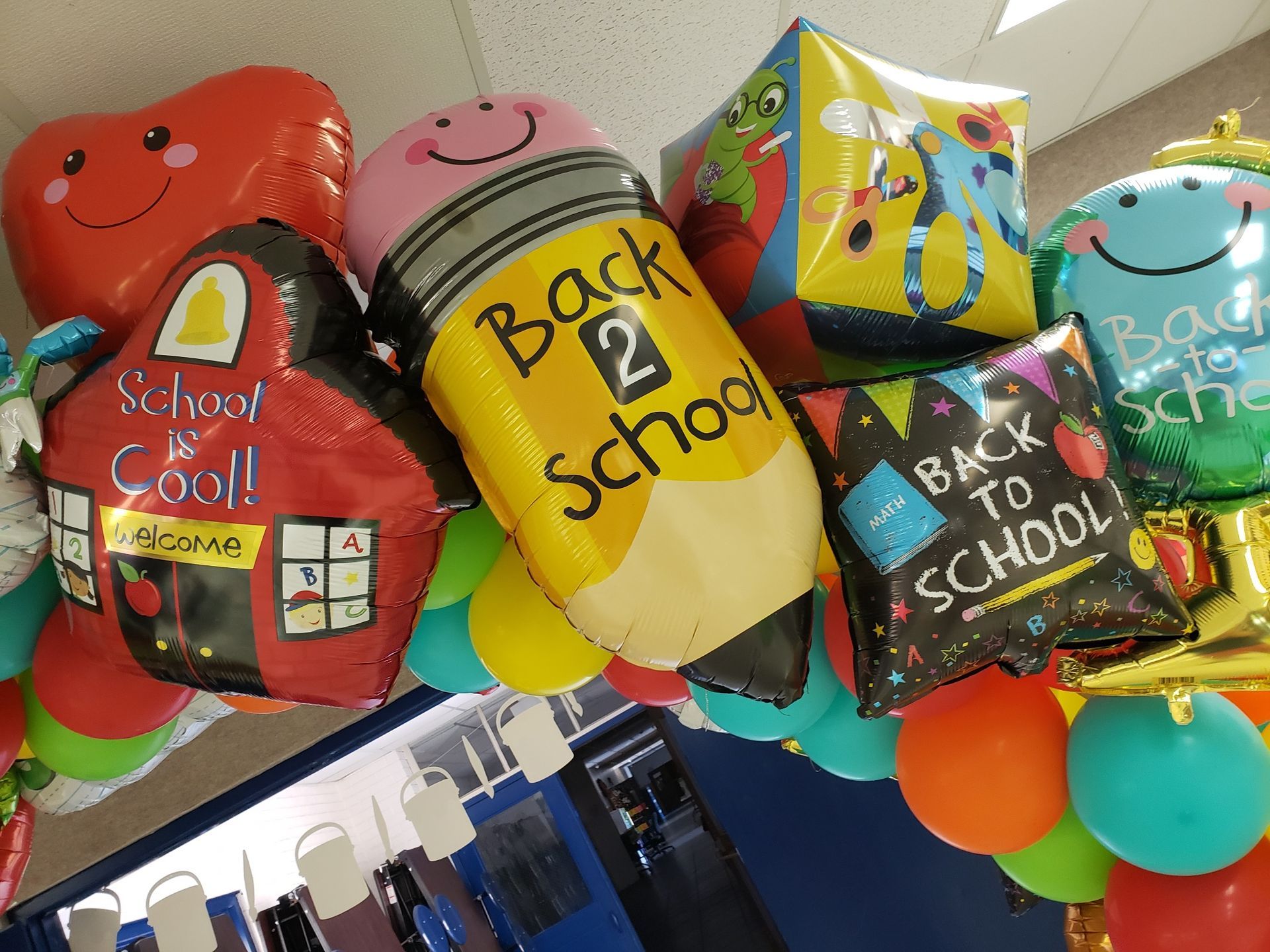 A bunch of back to school balloons hanging from the ceiling
