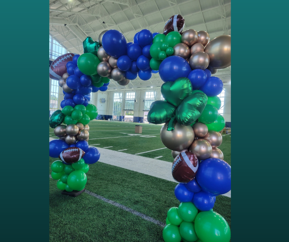 A bunch of balloons are sitting on top of a football field.