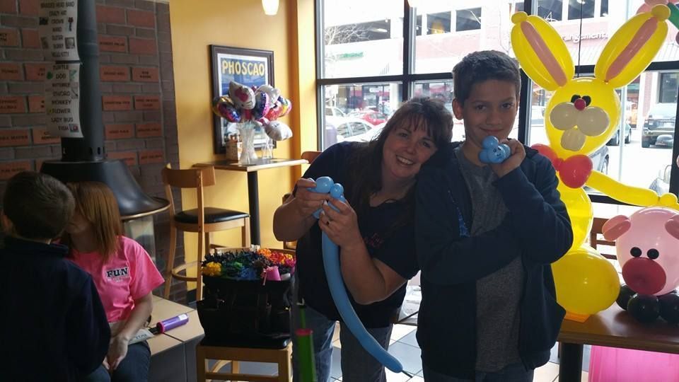 A boy and a woman are blowing up balloons in a room.  Easter balloon bunny.  Balloon Twisting Entertainment