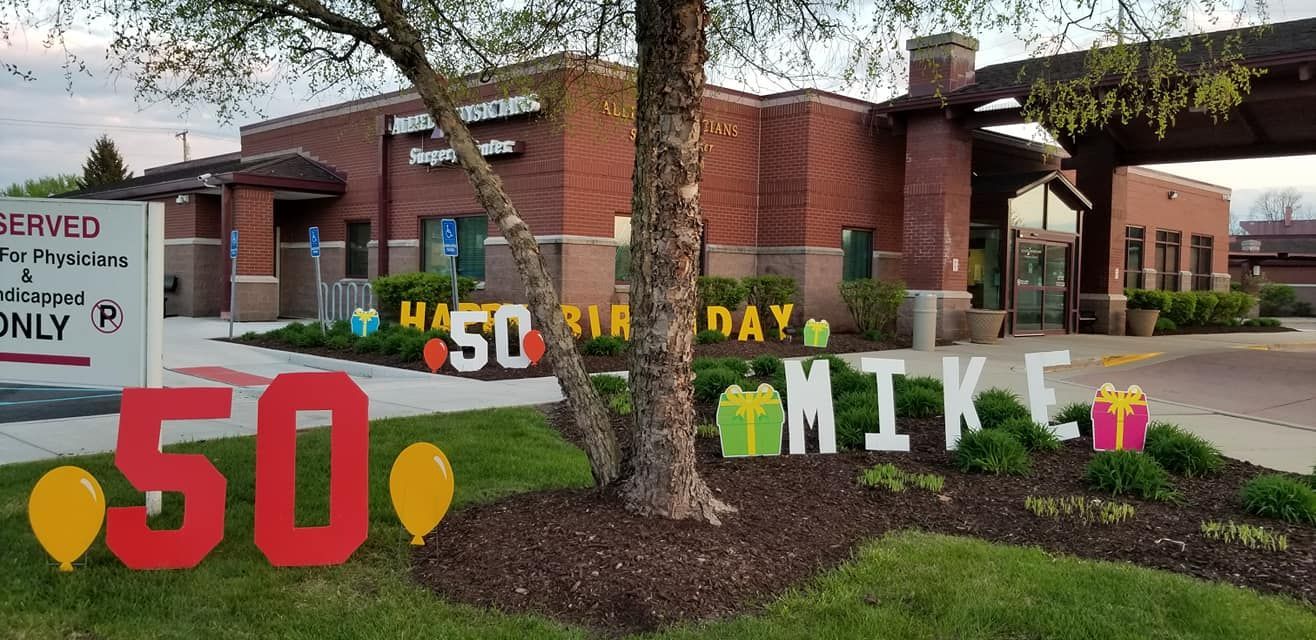 A sign for mike 's 50th birthday is in front of a building.