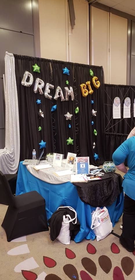 A room with a table and chairs and balloons that say `` dream big ''.