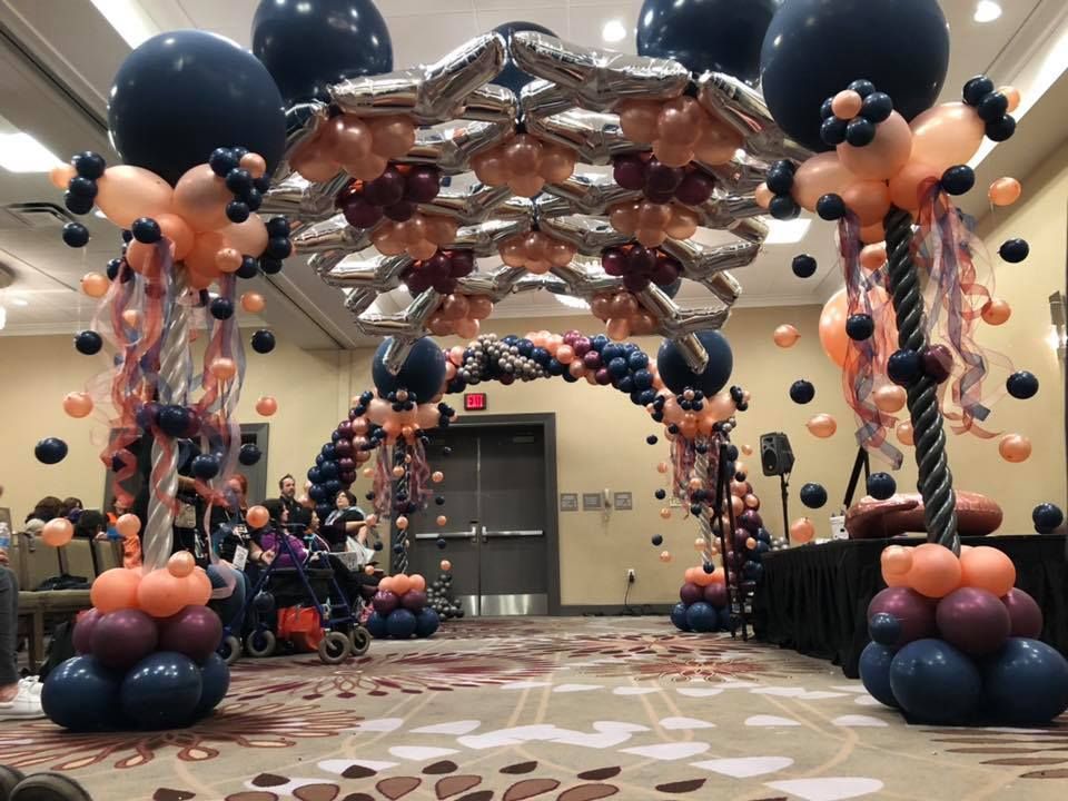 A room is decorated with balloons and a large arch.