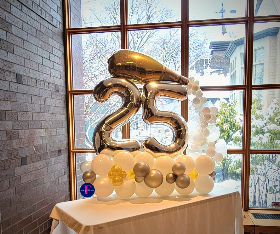 A table with balloons in the shape of the number 25. Balloon Marquee