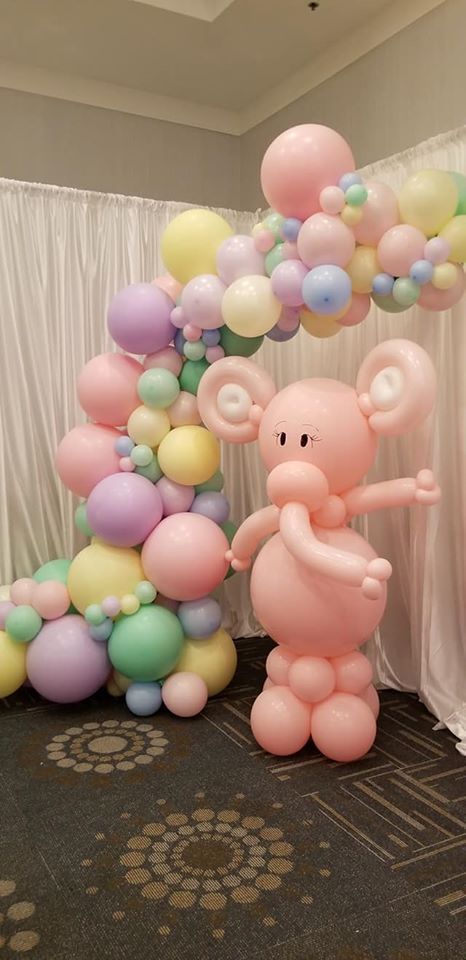 A pink elephant made out of balloons in a room. Baby Shoer.