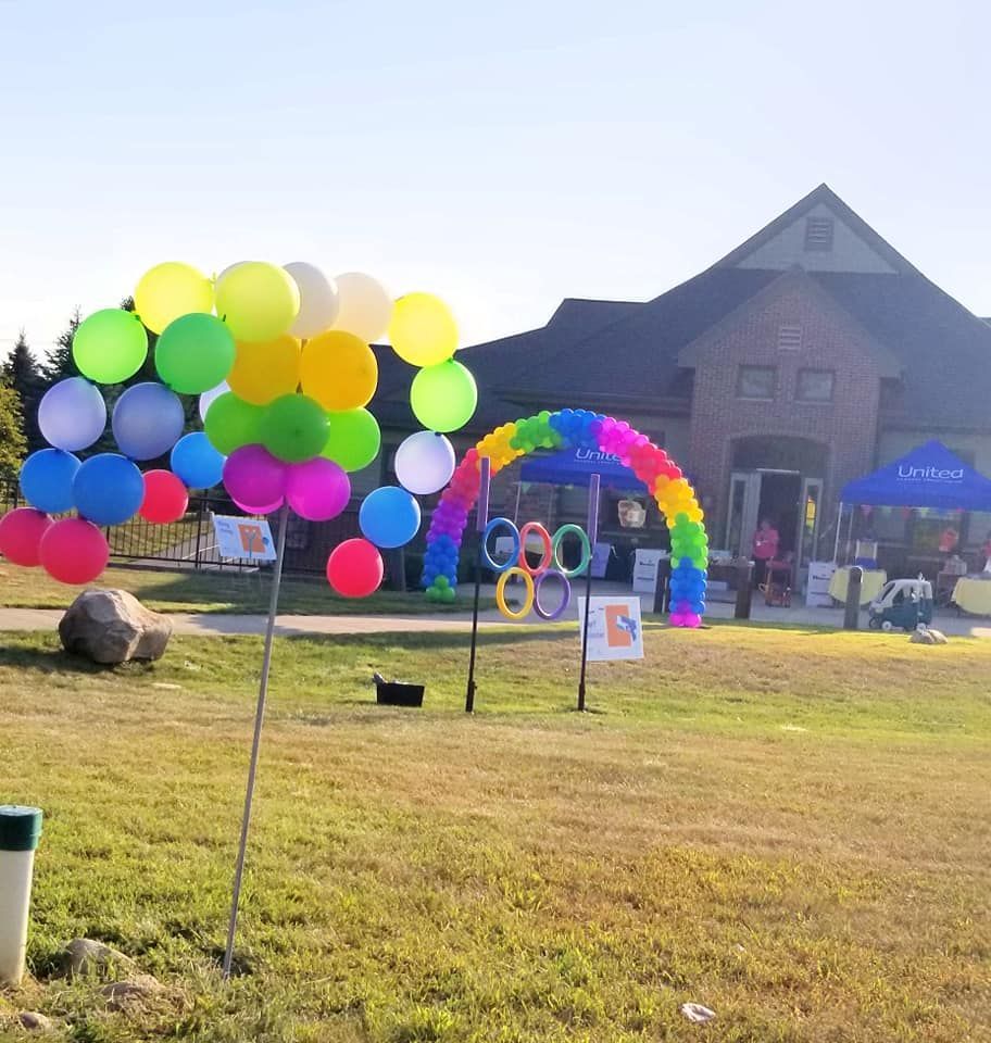 A bunch of colorful balloons in front of a building