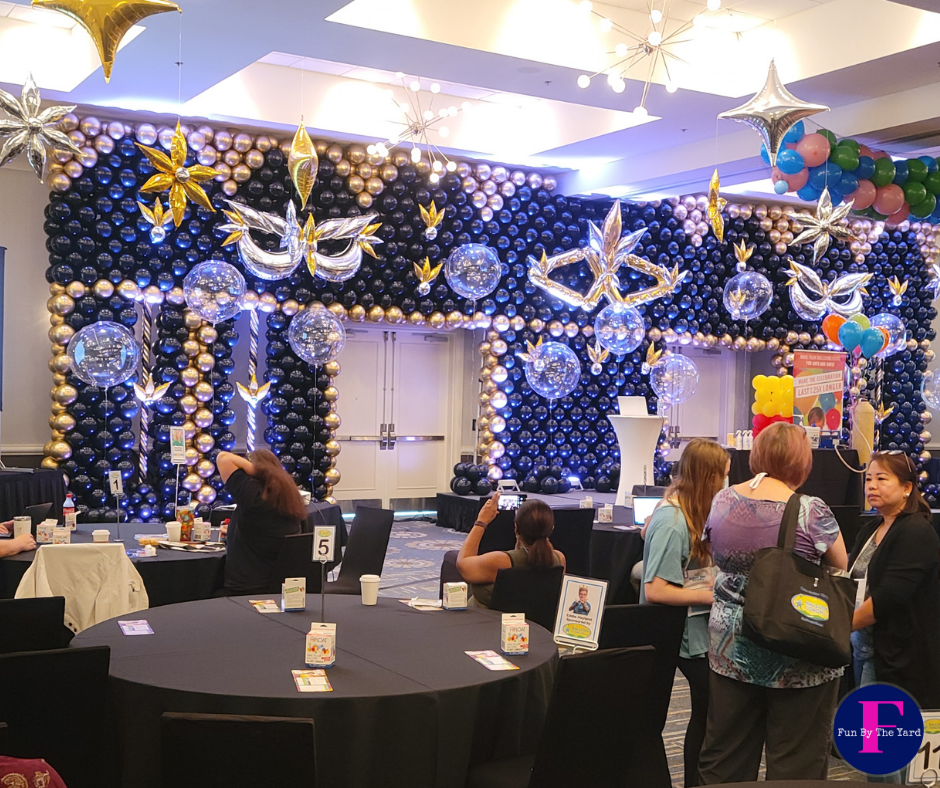 A room with tables and chairs and balloons on the wall