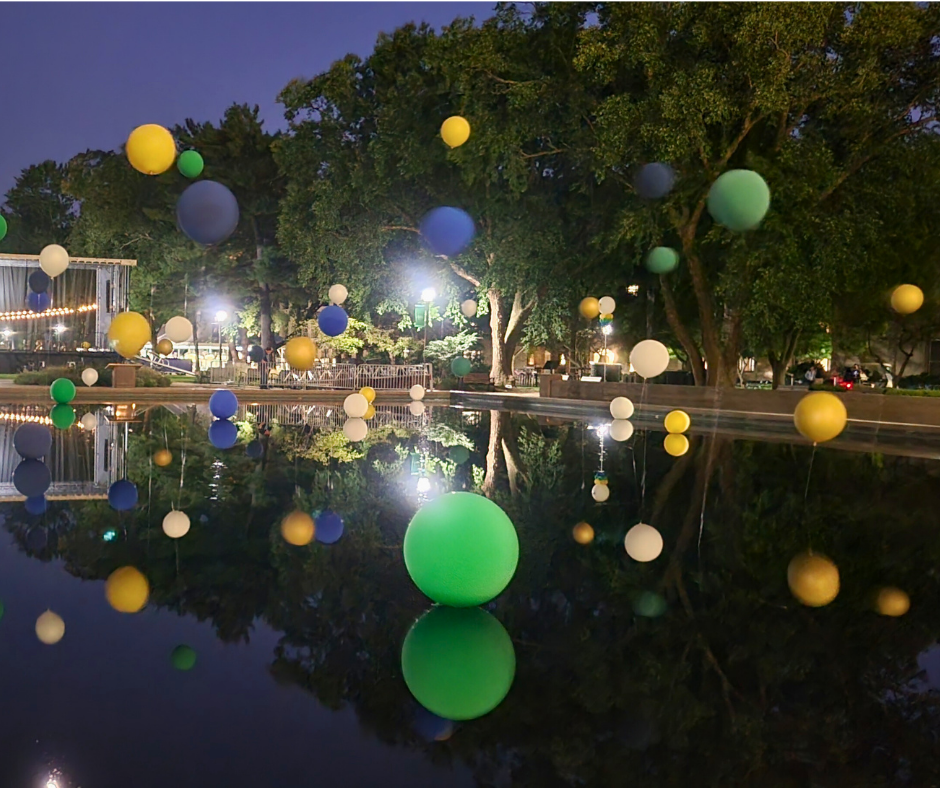 A bunch of balloons are floating in the water