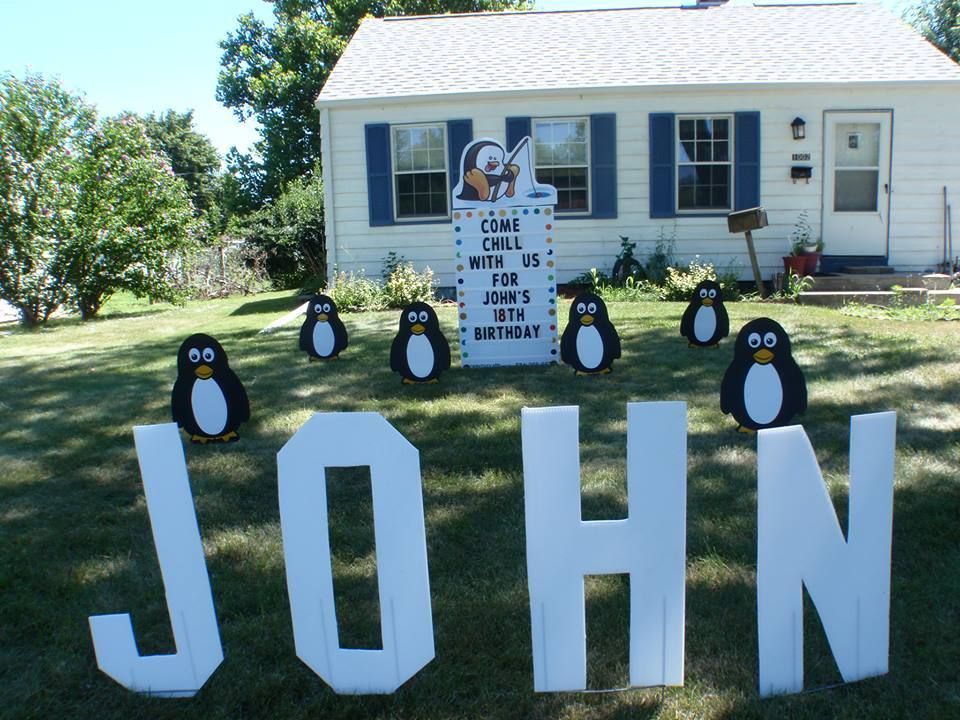 A white house with penguins and the name john. Penguin themed yard card.