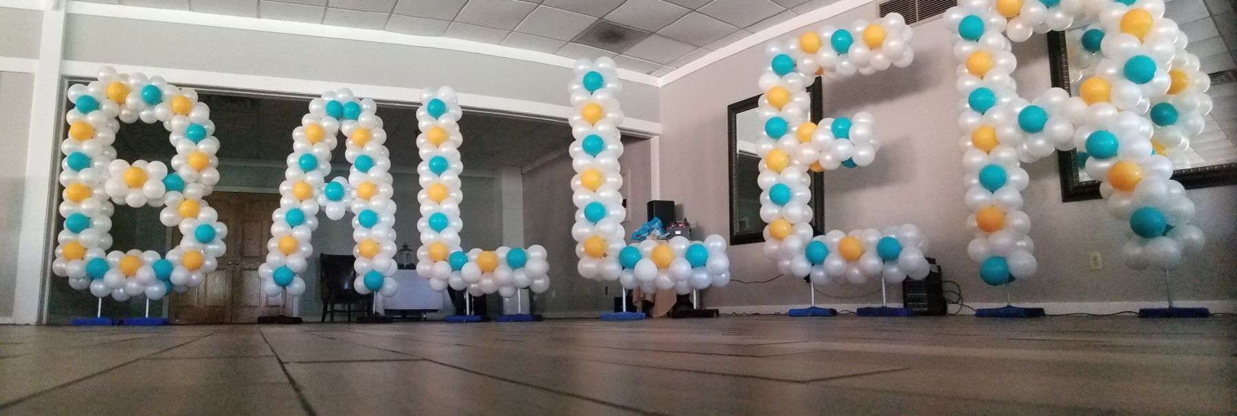 The word baller is made out of balloons in a room.