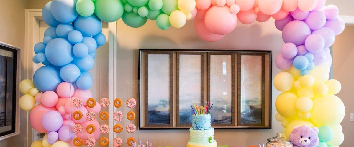A room decorated with balloons and a cake for a birthday party.