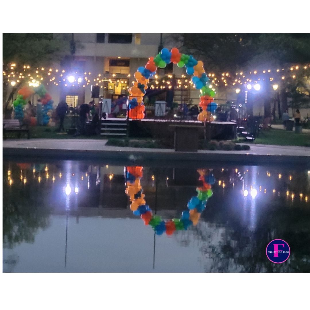 a circle of balloons is reflected in a body of water