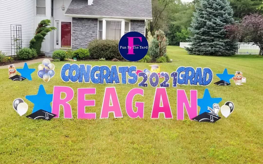 A yard sign that says `` congratulations 2021 grad reagan '' is in front of a house.