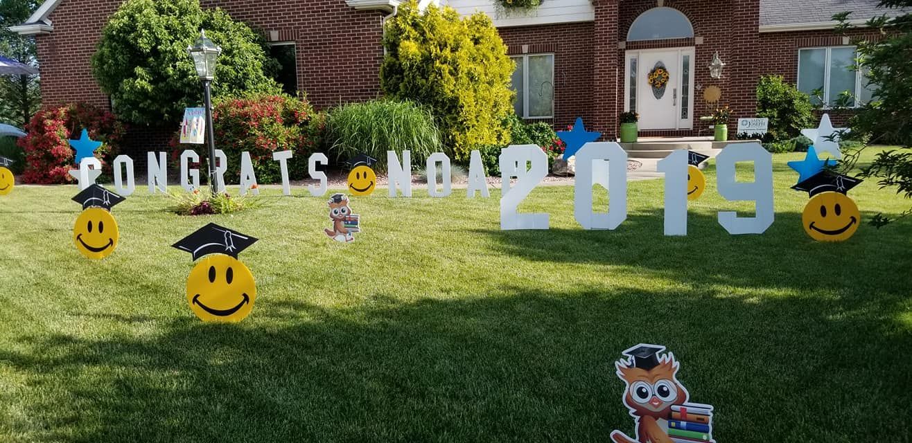 A yard sign that says `` congratulations graduates of 2019 '' is in front of a brick house.