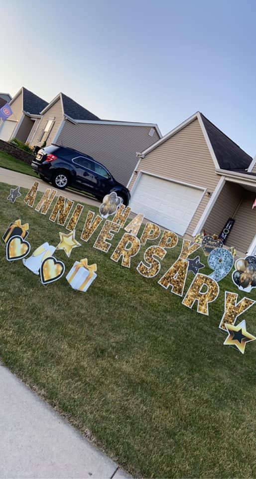 A row of anniversary signs in front of a house.
