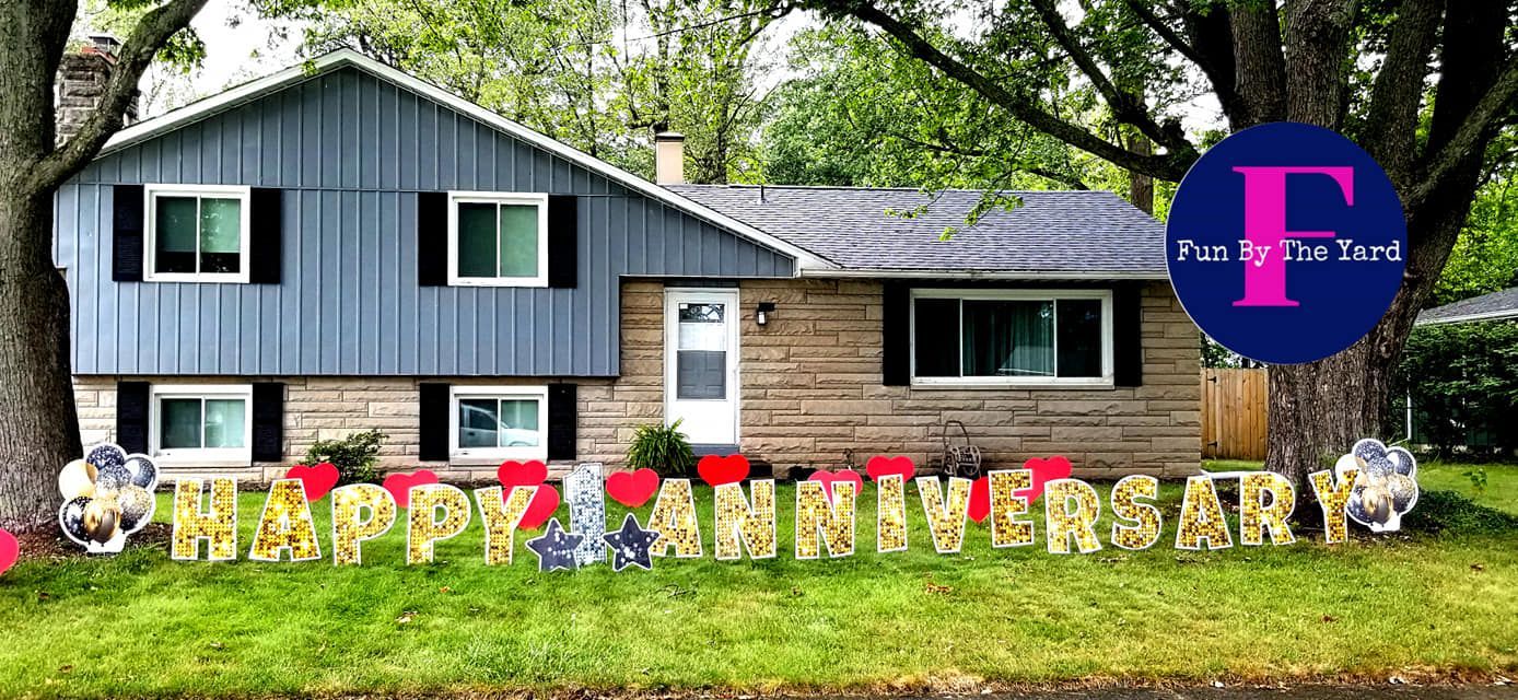 A house with a happy anniversary sign in front of it.