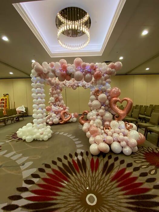 A room filled with balloons and a chandelier.