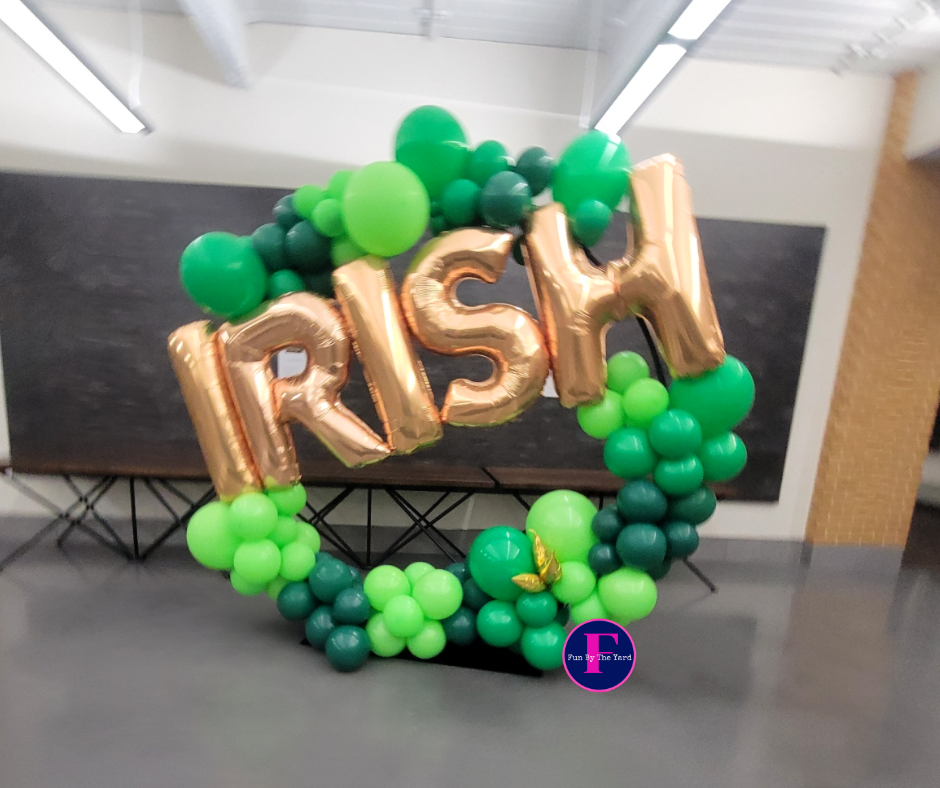 a wreath made of green and gold balloons says irish