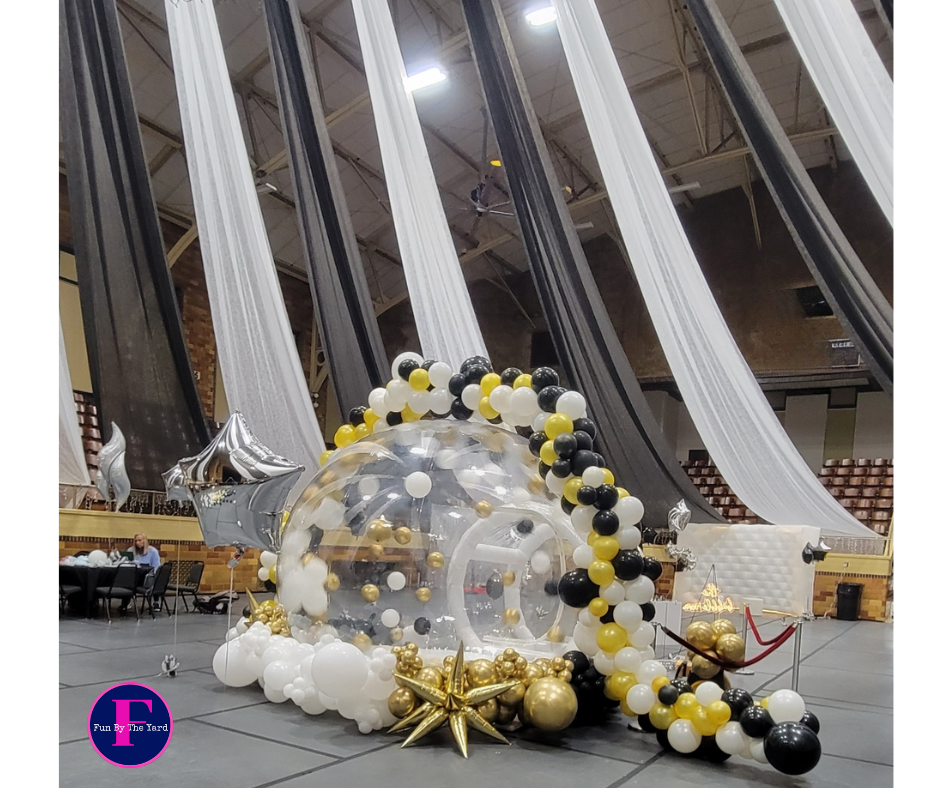 People releasing blue, white, and silver balloons at an indoor celebration.
