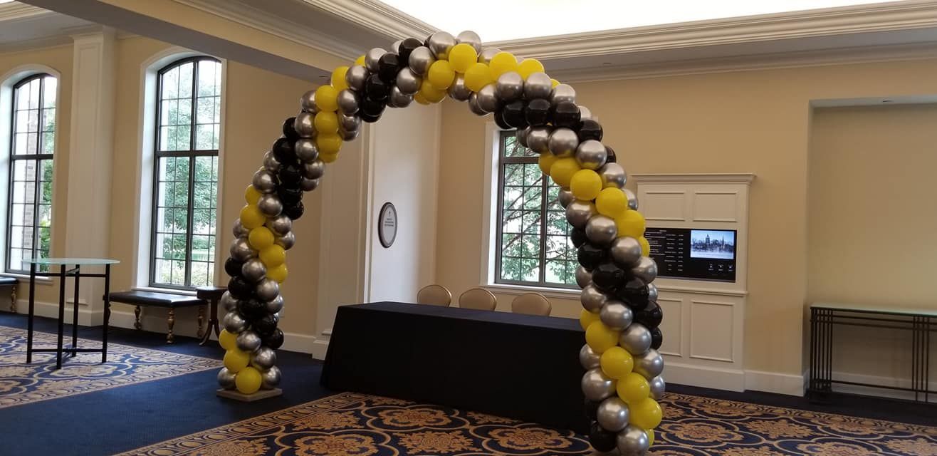 a room with a table and a balloon arch in it