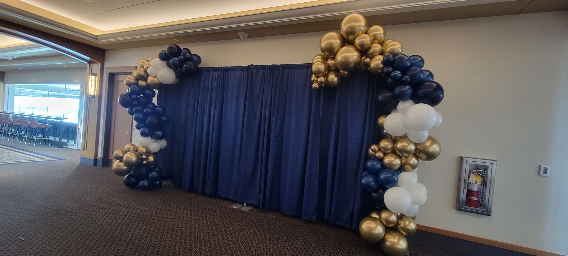 a room filled with balloons and a blue curtain