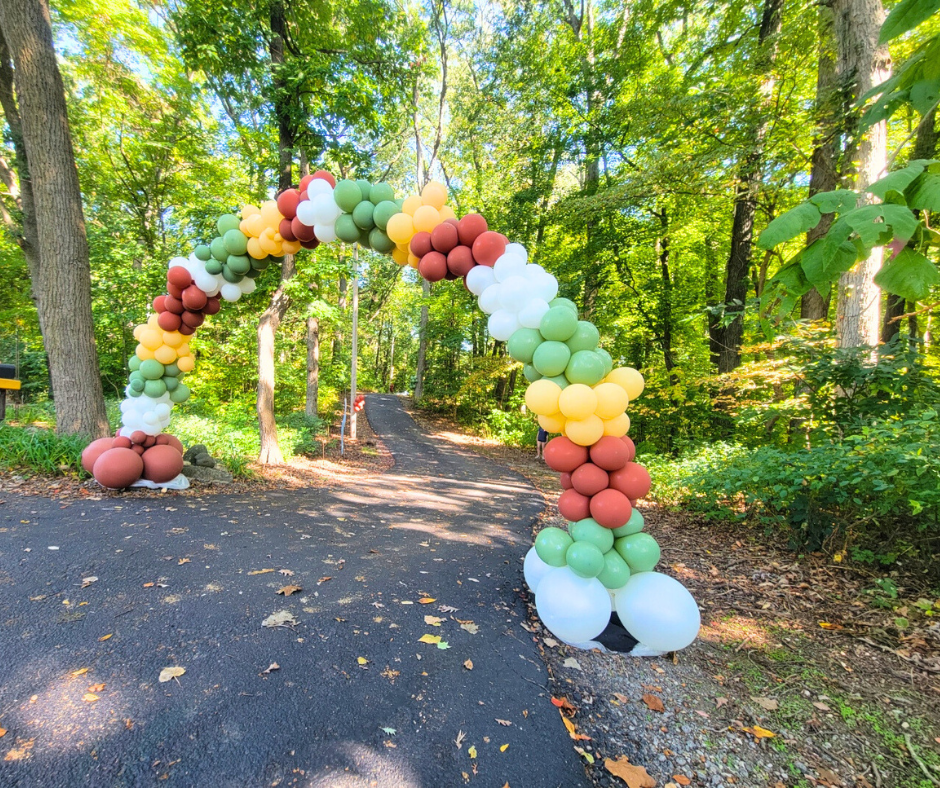 A balloon arch are lined up on the side of a road in fall colors