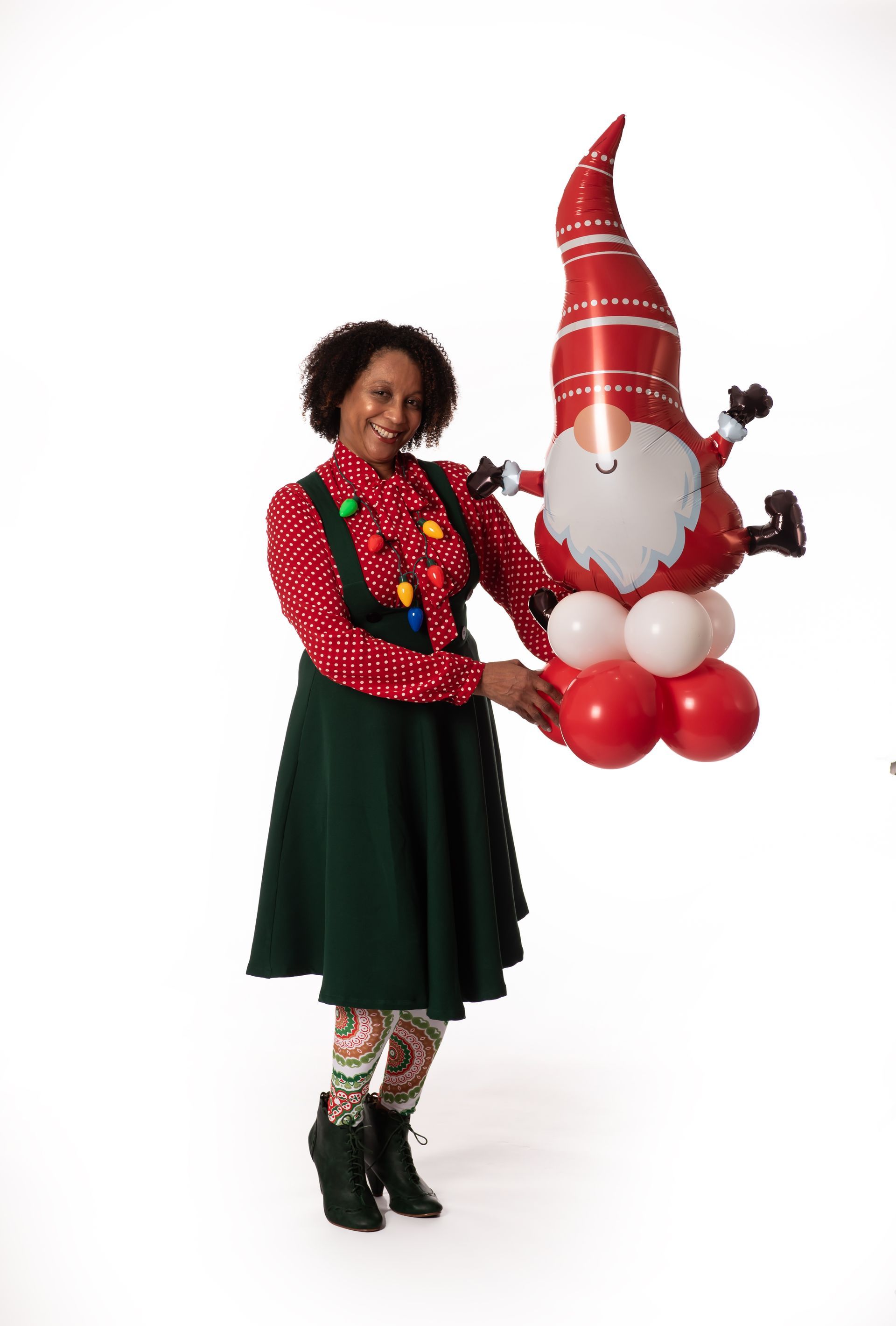 A woman is holding a balloon in the shape of a gnome.