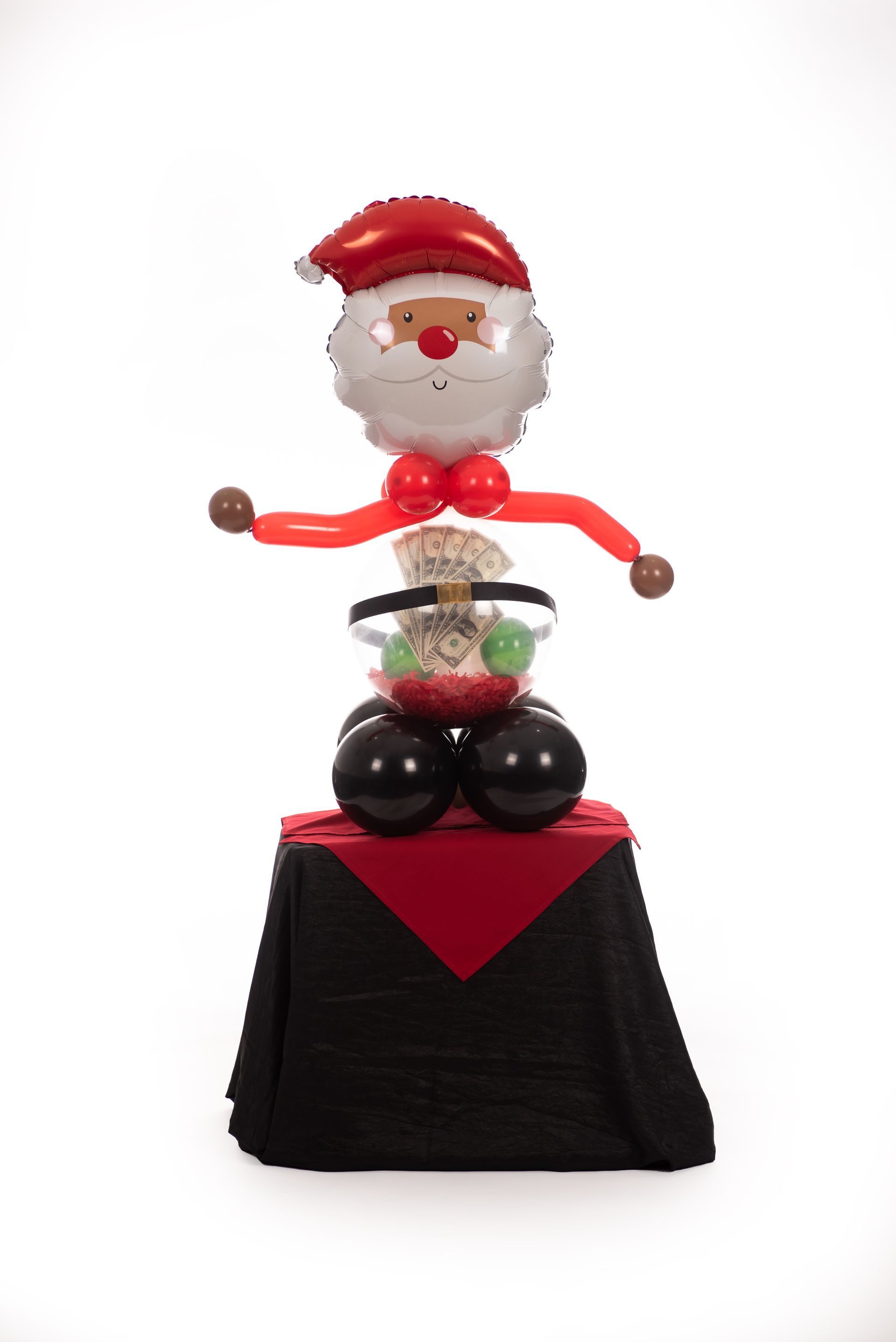 A santa claus made out of balloons is sitting on top of a table.