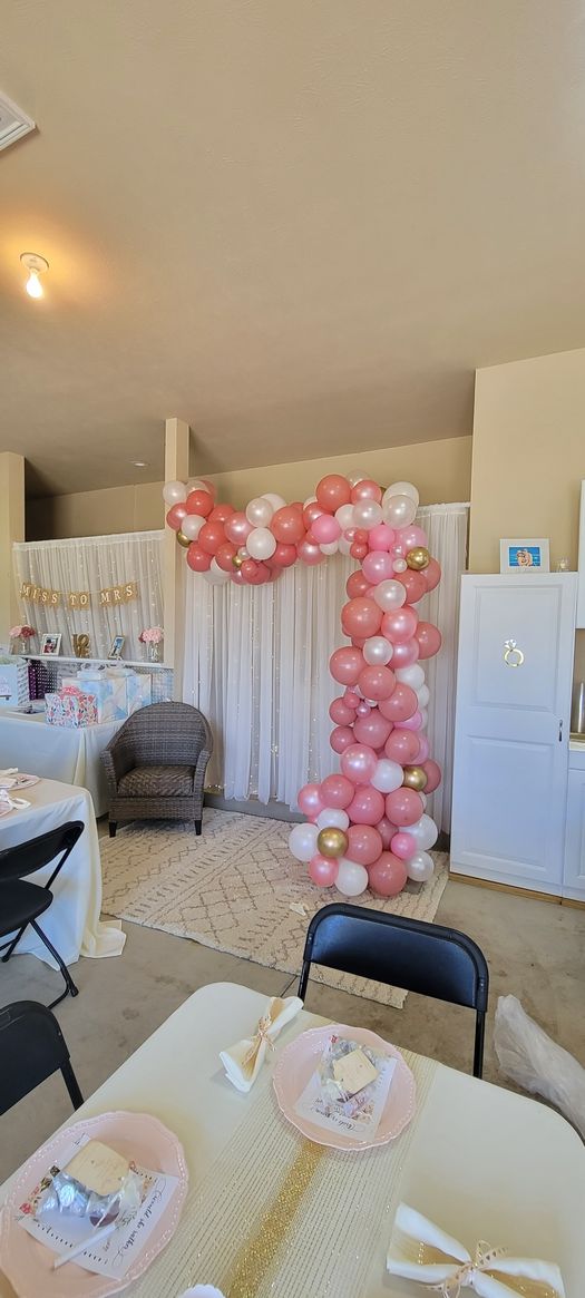 A room with a table and chairs and balloons on the wall.