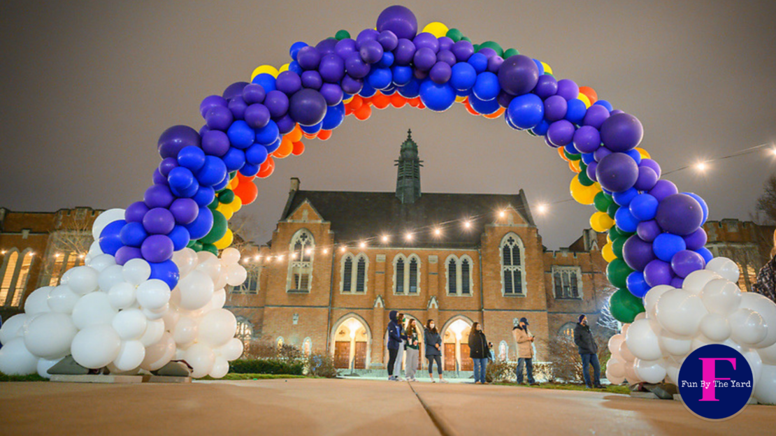 a large arch made of balloons is in front of a building