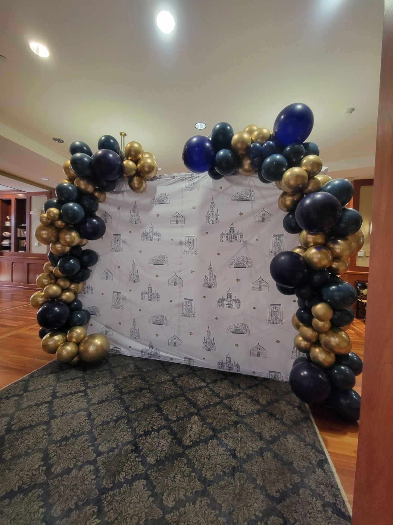 A wall covered in blue and gold balloons in a room.