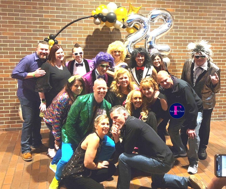 A group of people posing for a picture in front of a brick wall