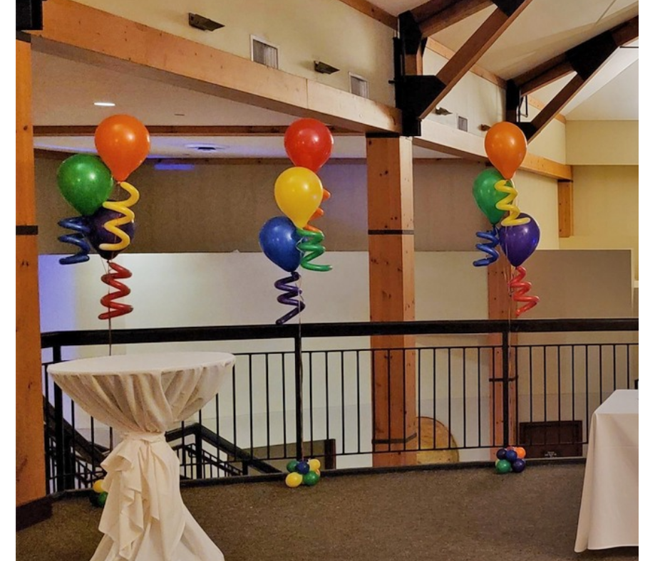 A room with balloons and swirls hanging from the ceiling