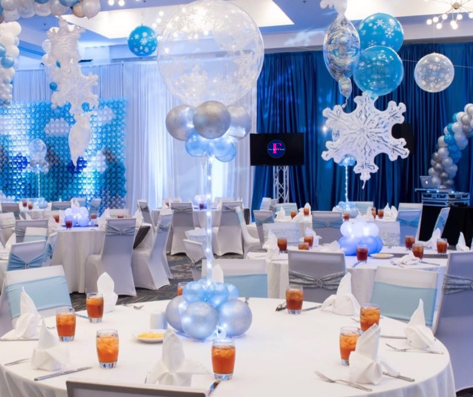 A large room with tables and chairs decorated with balloons and snowflakes