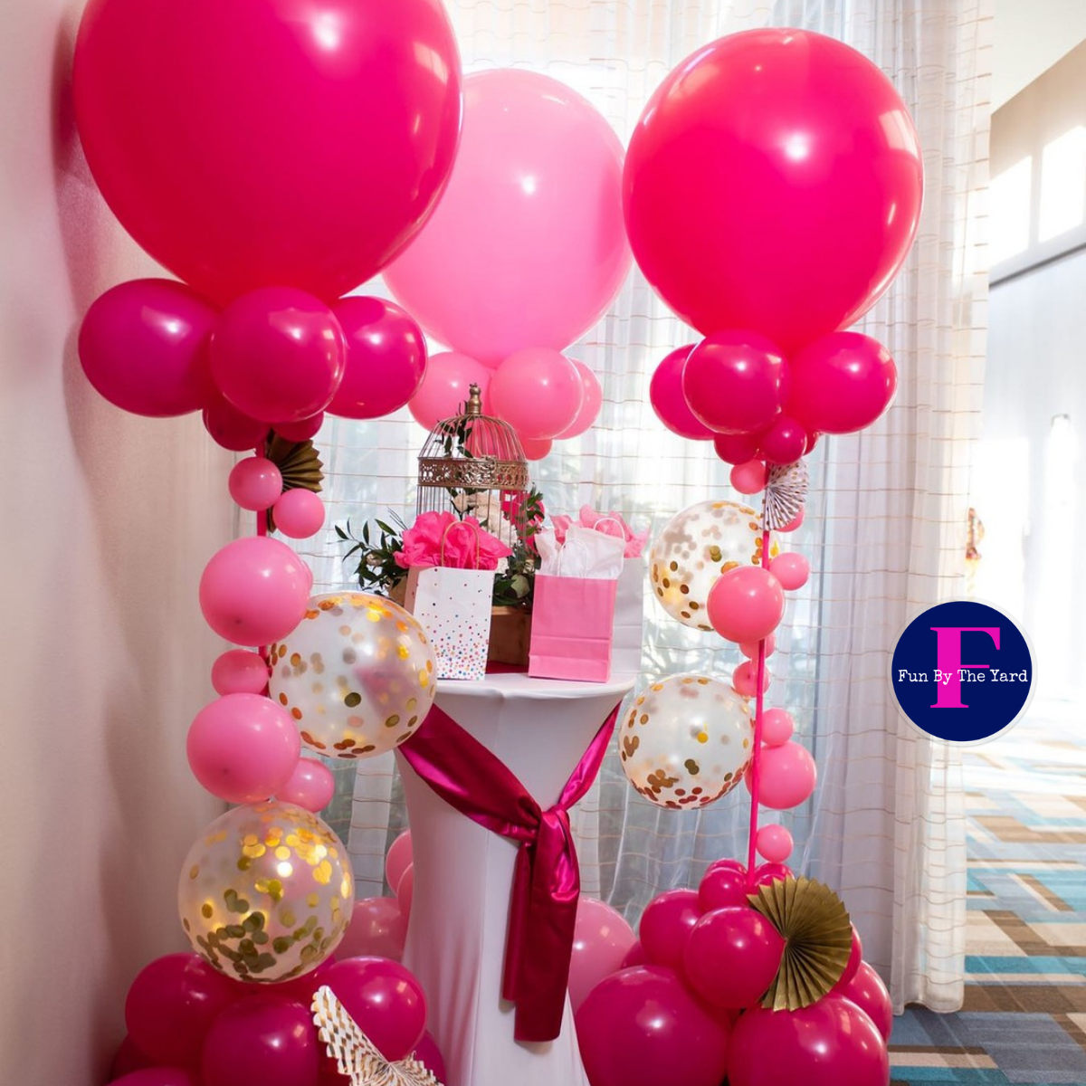 A bunch of pink balloons are sitting on a table
