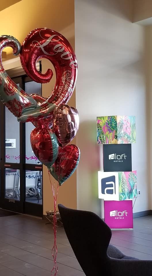 A bunch of red heart shaped balloons in a room