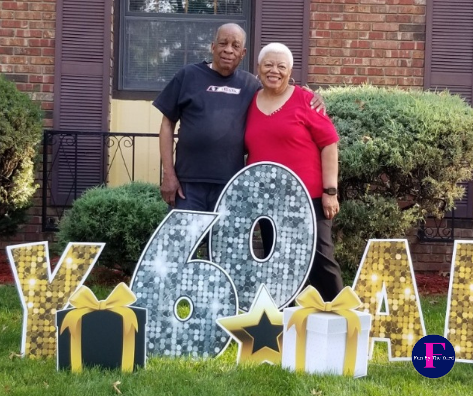 A man and woman standing in front of a sign that says 40