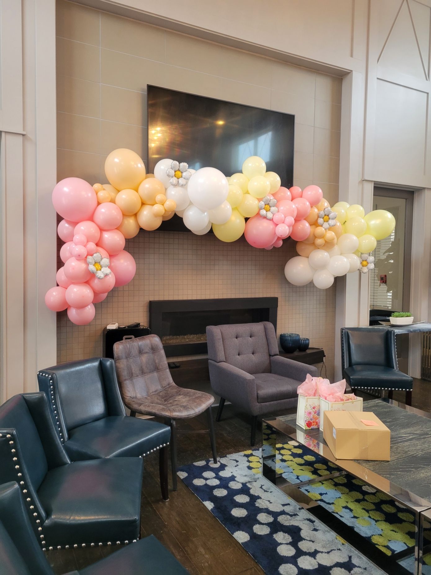 An organic free form balloon garland for a baby shower with daisys