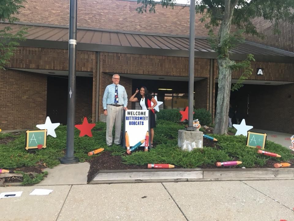 People standing outside school building with a 