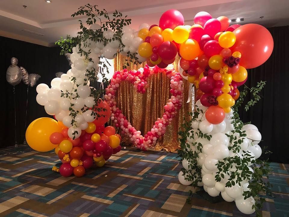A room decorated with organic balloons and a heart in the middle for a Valentine's Day wedding
