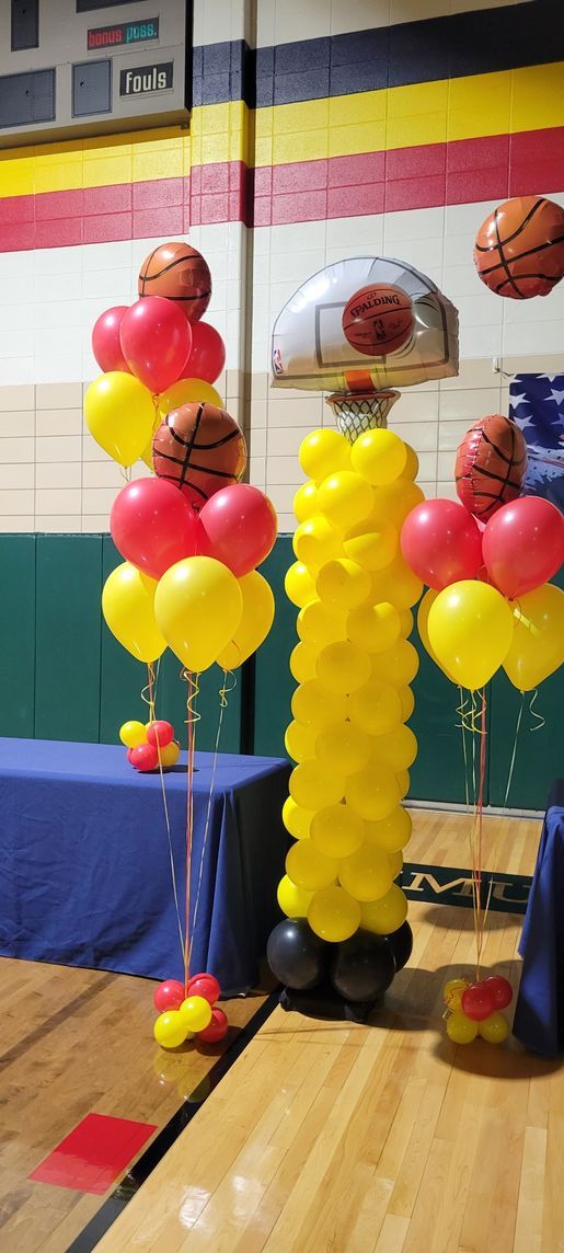 A basketball hoop made out of balloons in a gym.
