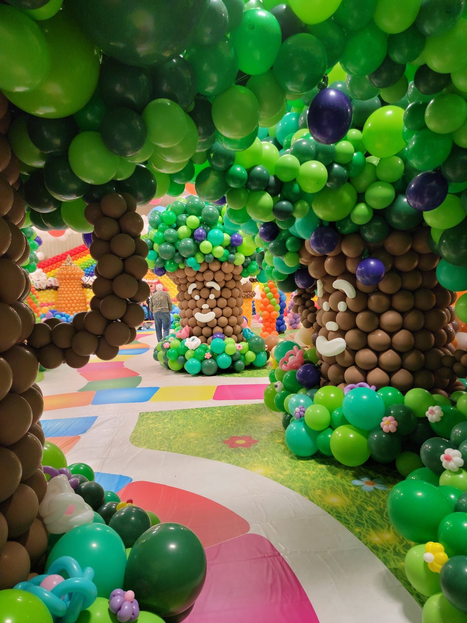 A hallway filled with balloons decorated to look like trees. Candy Land