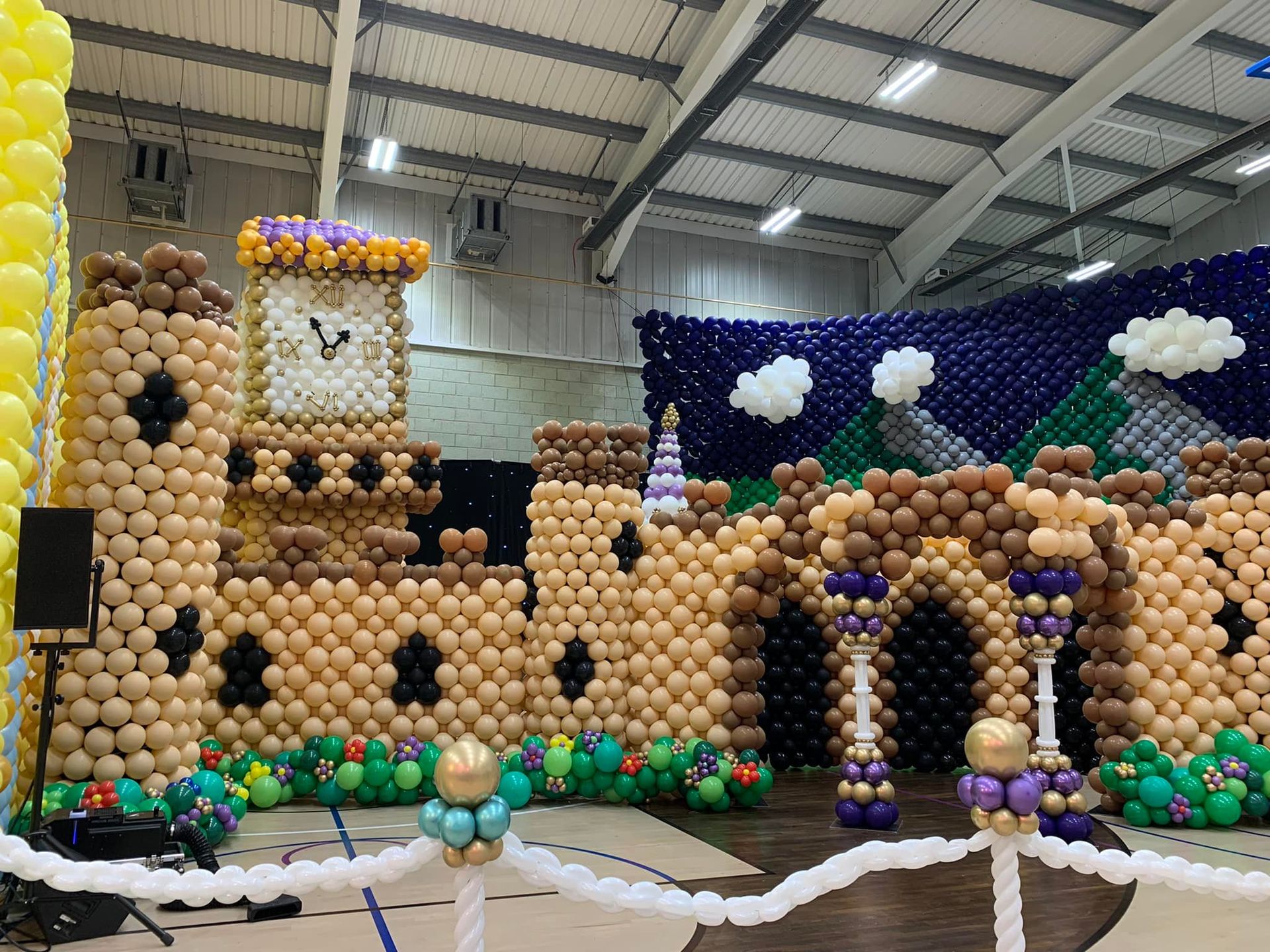A castle made out of balloons with a clock on top of it.