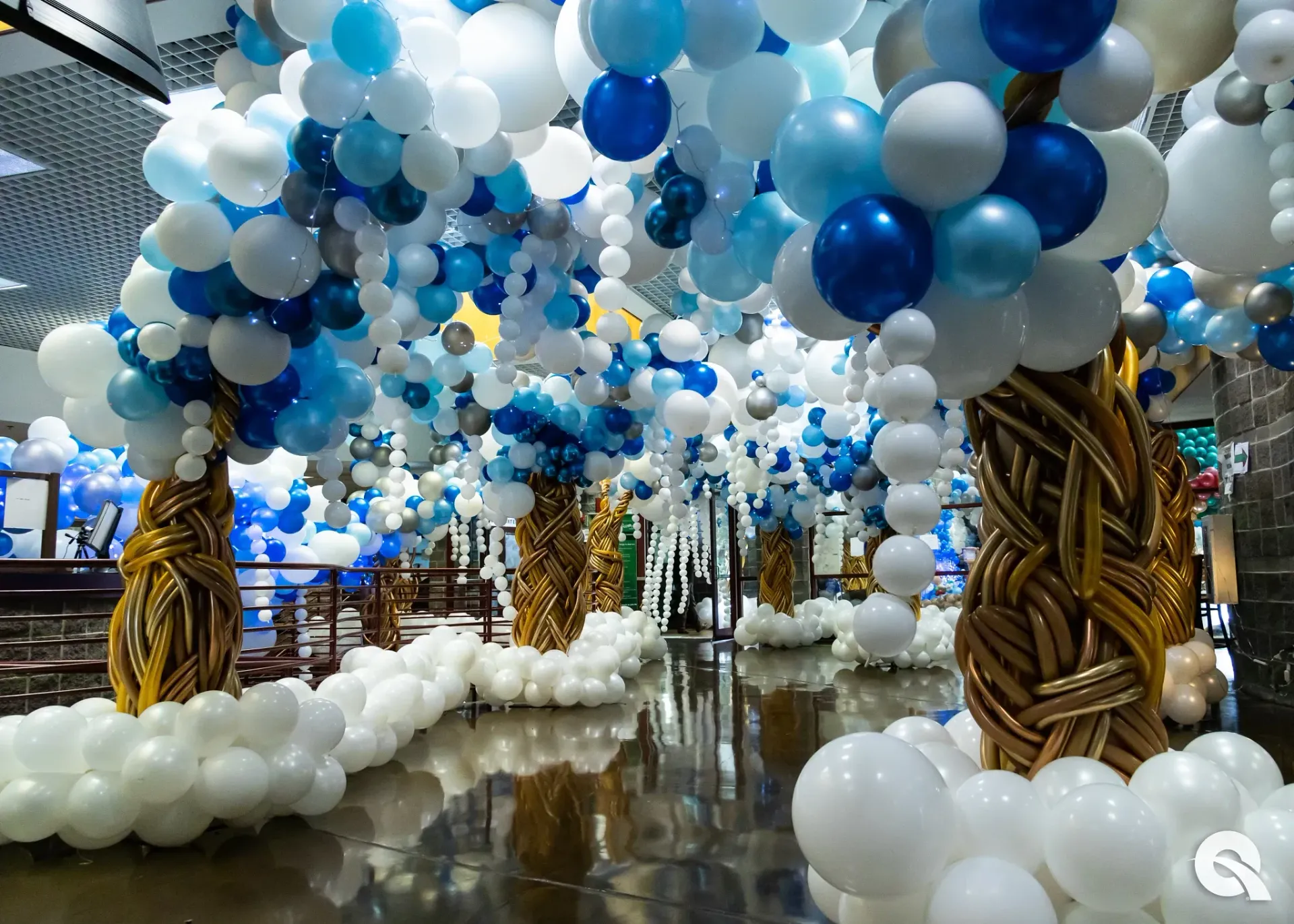 A room filled with blue and white balloons shaped like a forest of trees