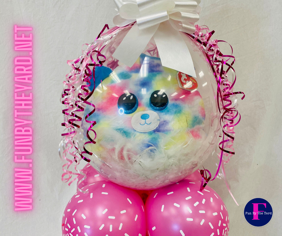 A stuffed animal in a balloon surrounded by pink balloons